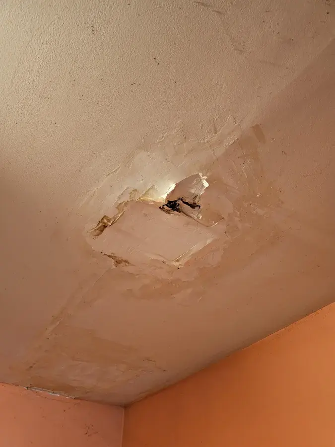 Water-damaged ceiling broken open above an apartment room in Canoga Park